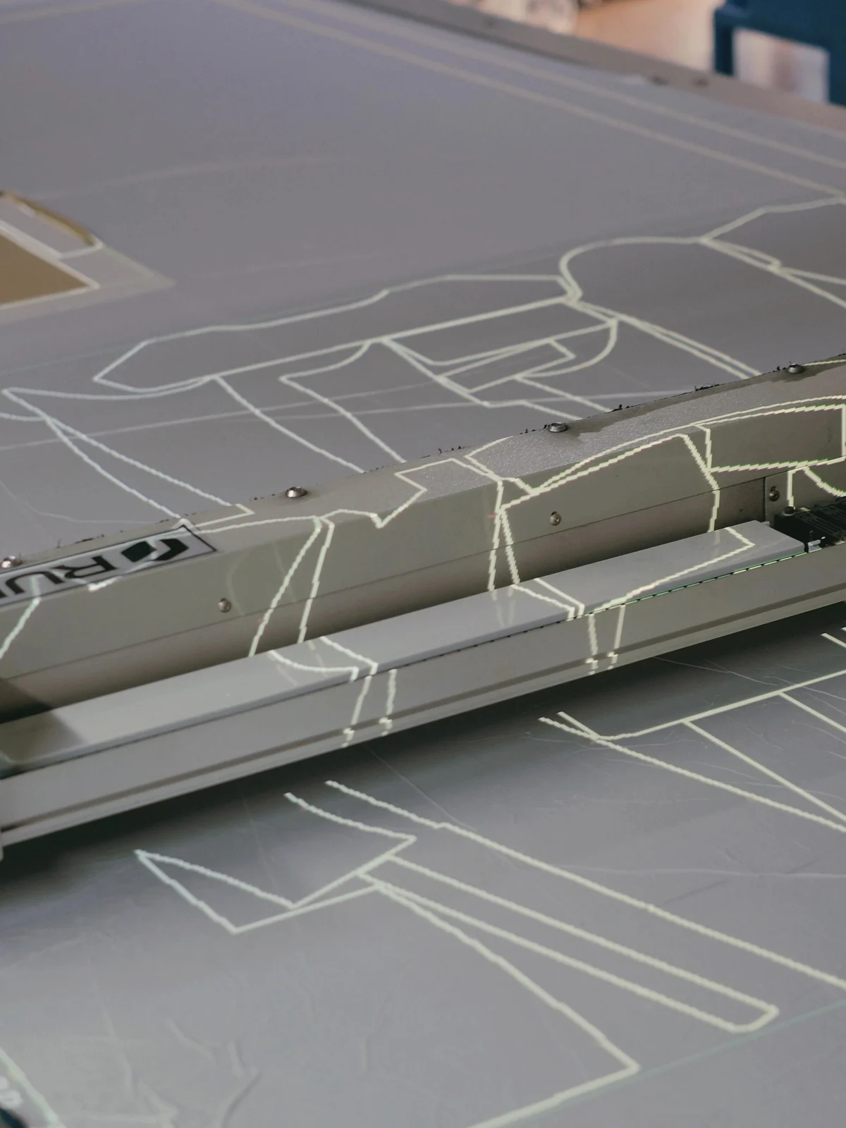 Marked garment outlines and paper patterns on a cutting table.